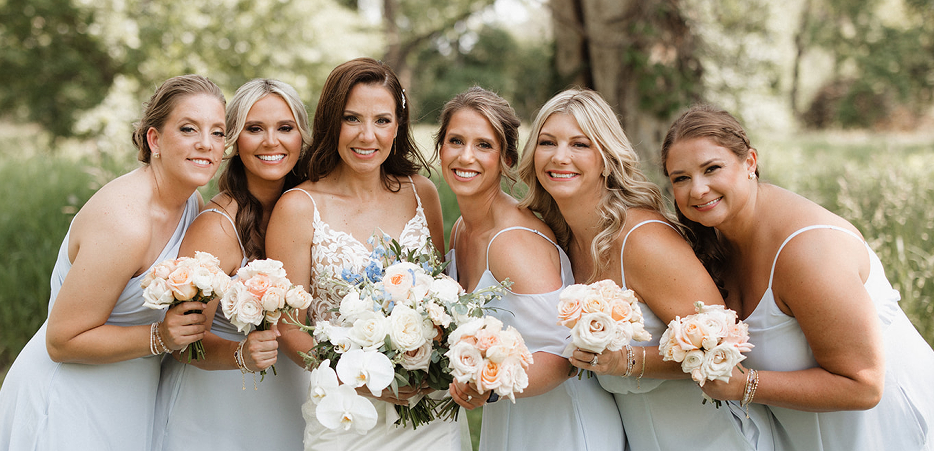 Bridal party smiling and holding flowers
