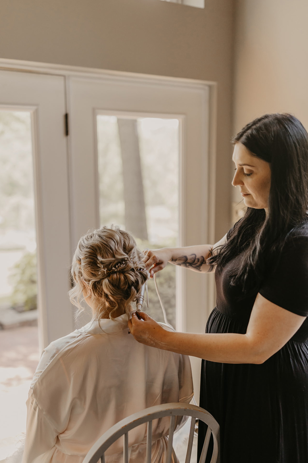 Bride having hair done by stylist