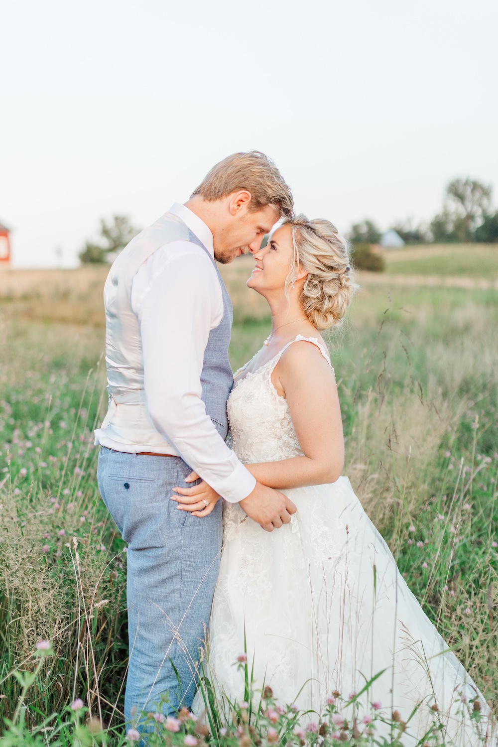 Bride and groom standing in field
