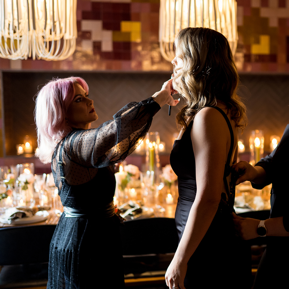 Bride snd stylist in chandelier lit room
