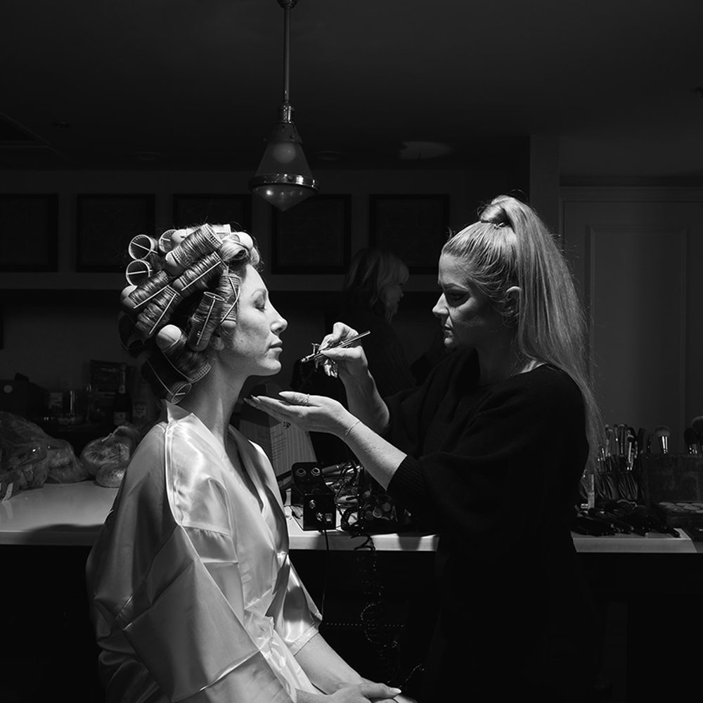 Artist applying makeup to bride